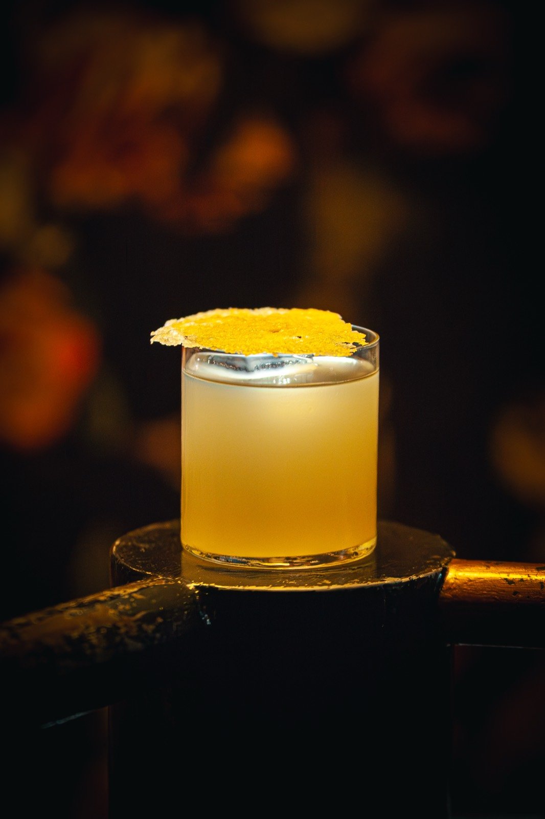 Un cocktail doré coiffé d’une mousse claire et d’une garniture d’agrume